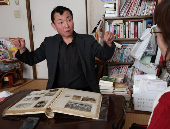 母・昌子さんの遺影の前で、幼い頃から聞いていた戦争体験を教えてくれた牧山さん